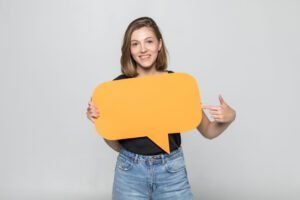jovem segurando bolha amarela de conversa