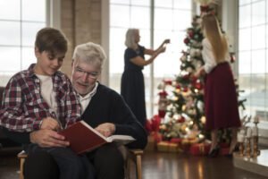 Muito Além dos Presentes: O Que o Natal Realmente Celebra? avô lendo história de natal para o neto