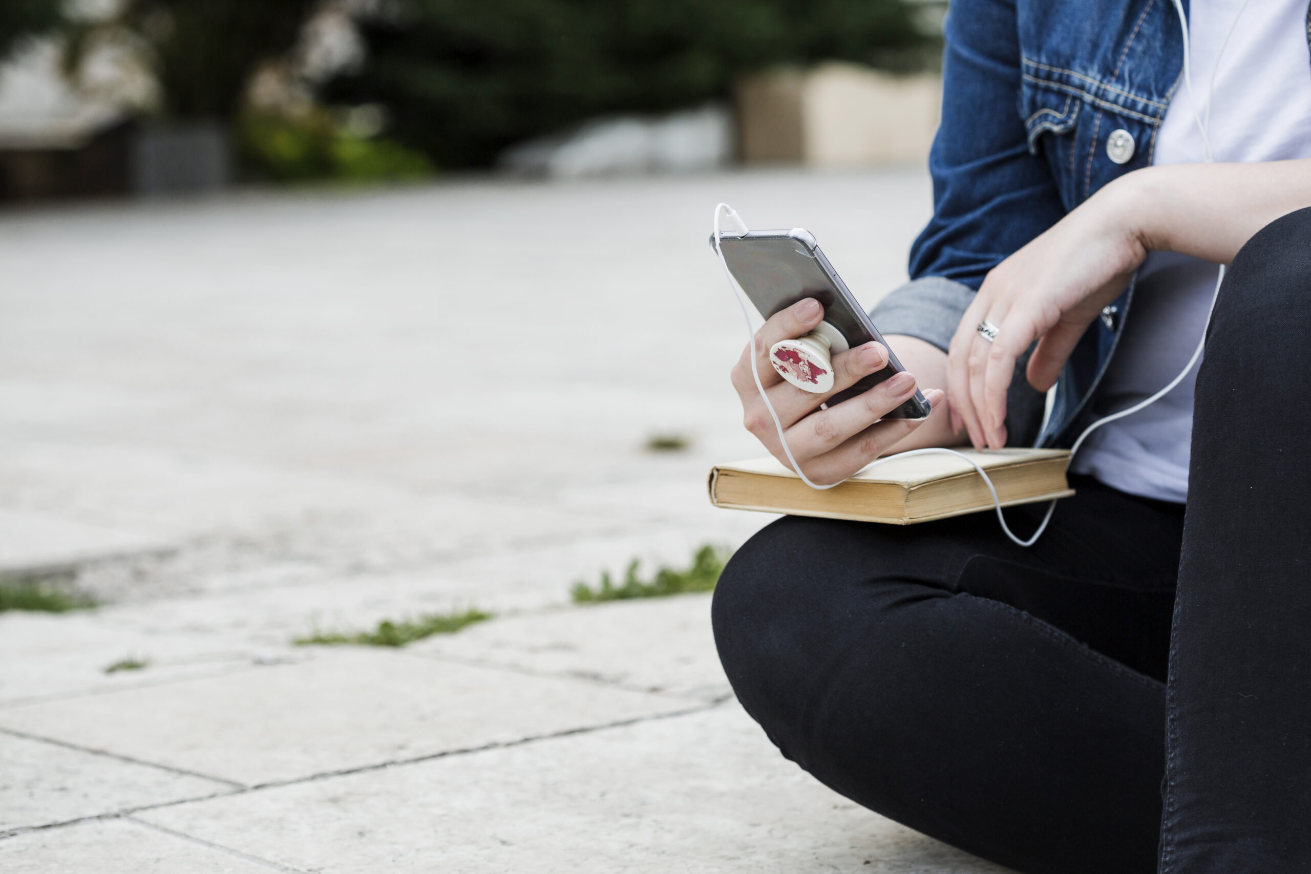 mulher-de-colheita-usando-smartphone-sentado-na-calcada-scaled O Alerta Silencioso: Estamos Vivendo o Fim dos Heróis da Fé e Não Percebemos?