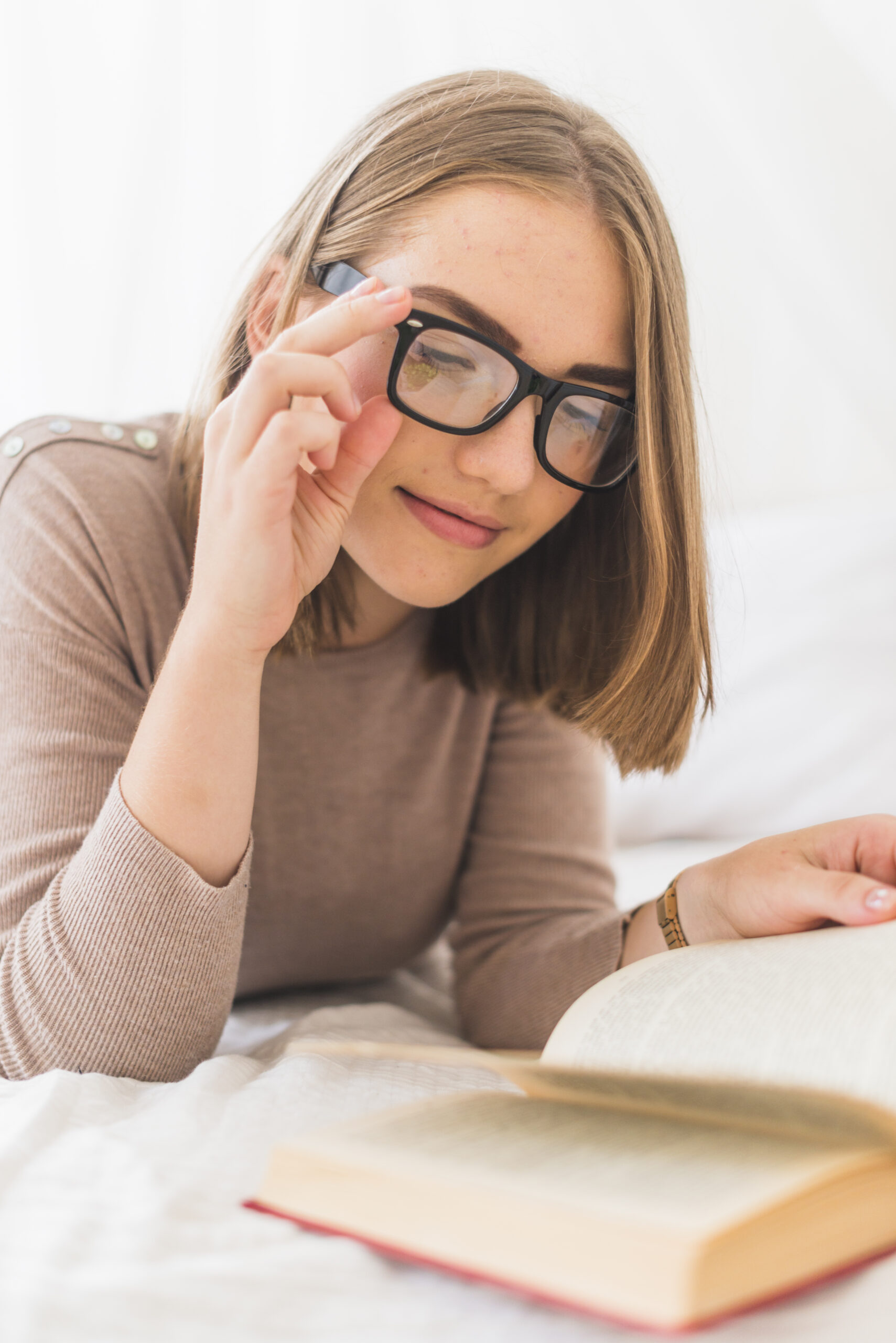 attractive-young-woman-wearing-spectacles-reading-book-scaled O Segredo da Lente Certa: Como a Eternidade Cura a Nossa "Miopia Espiritual"